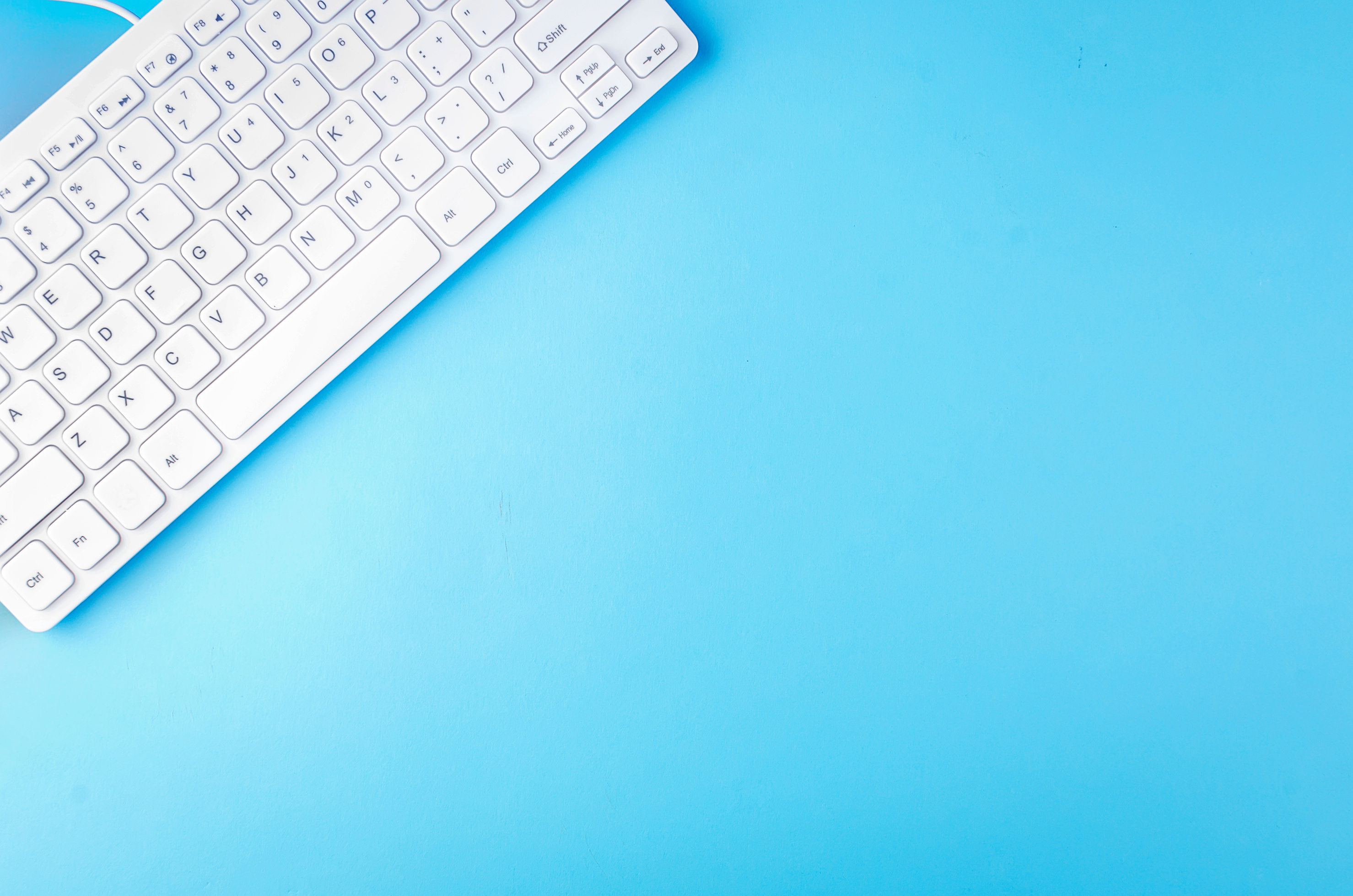 Top View of White Keyboard on Blue.Woman Freelance Background.